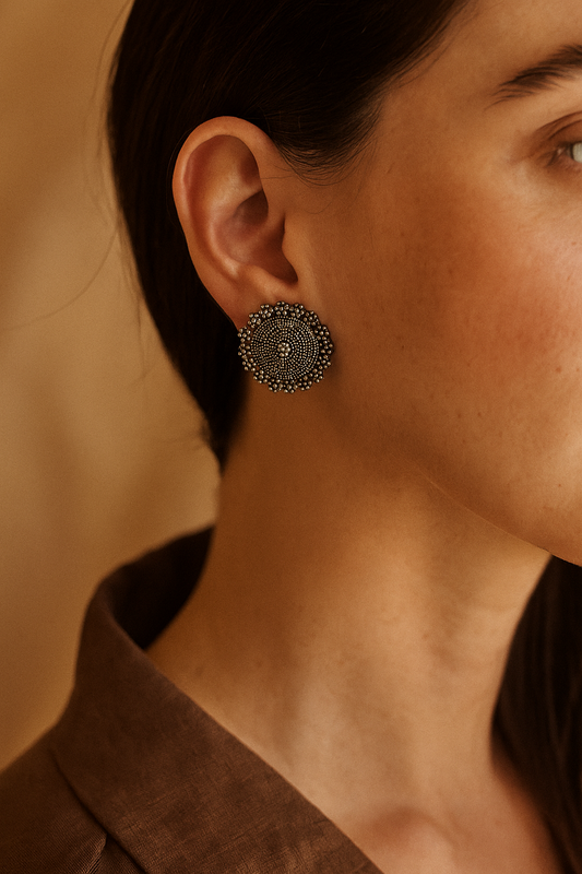 Close-up of a person wearing a decorative earring with a blurred background